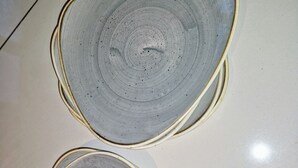 Two ceramic plates with concentric circles on a reflective surface.