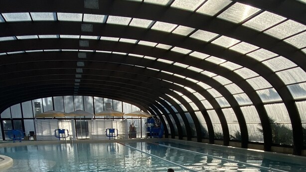 Ein Innenpool mit gewölbter Decke und klarem Wasser.