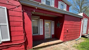 A red building with a brick entrance, white shutters, and a star decoration.