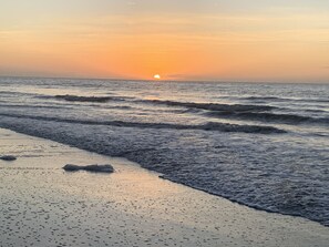 A beach with waves at sunset.