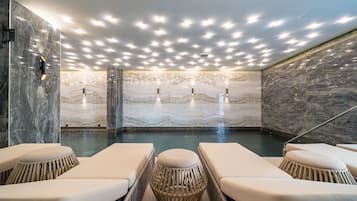 Una piscina techada, sillones reclinables de piscina