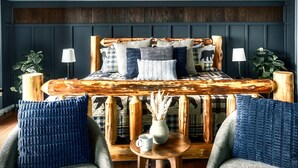 A bed with a wooden headboard, two lamps, and a small table with a vase.