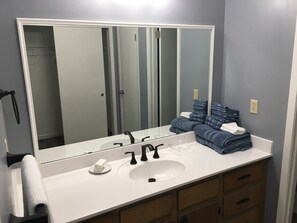 A bathroom with a large mirror, white sink, black faucets, and a towel rack. - Beautiful , private Bon Secour riverfront home with spacious screened porch (Bon Secour)