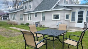 Una casa con patio, que incluye una mesa y cuatro sillas.