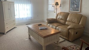 A living room with a beige sofa, a wooden coffee table, a white dresser, and a lamp. - Perfect Family Vacation House - Walk to Beach (Sylvan Beach)