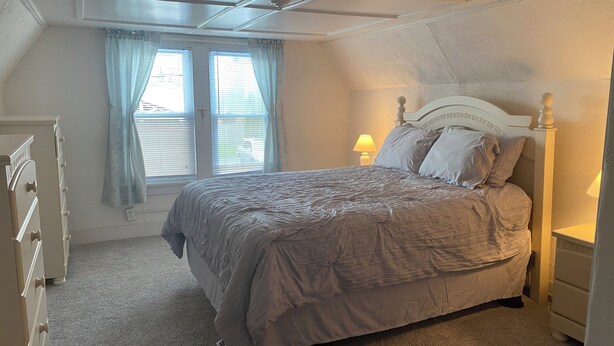 A bedroom with a bed, a dresser, a nightstand, and a window with curtains. - Perfect Family Vacation House - Walk to Beach (Sylvan Beach)