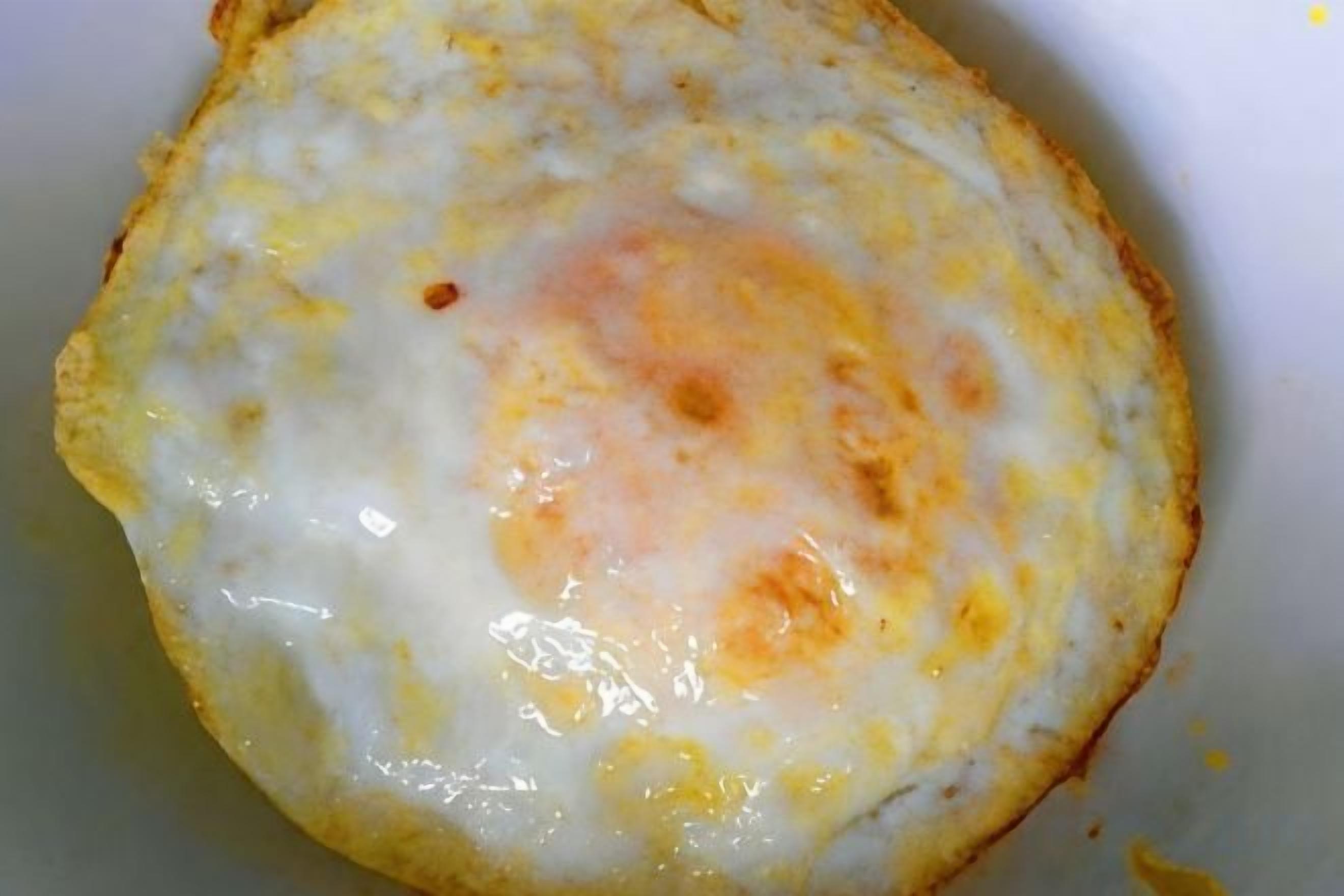 Primer plano de un huevo frito con yema líquida.