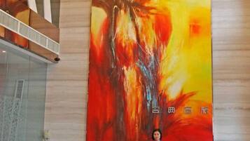 Iemand staat voor een groot abstract schilderij met Chinese karakters.