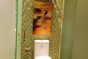 A bathroom with a tiled wall, a toilet, and a shower curtain. - Ganlu Hotel (Yunan) (Yunan)
