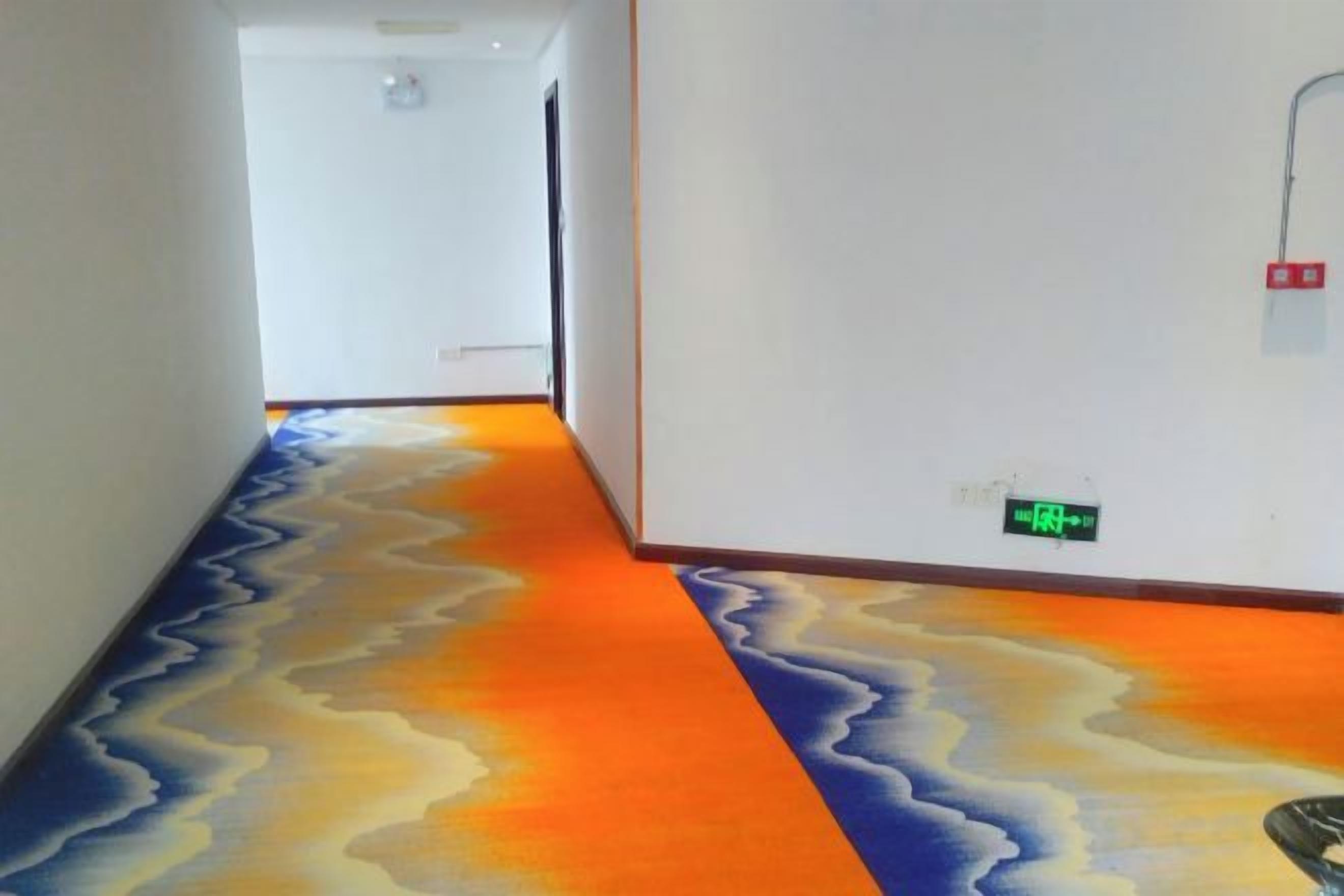 A hallway with a colorful, wavy carpet design.