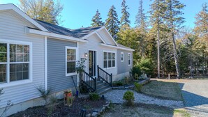 A single-story house with a front porch, a small garden, and a gravel driveway. - Golden Lantern @ Acadia National Park, A/C, Spacious, Seafood (Tremont)