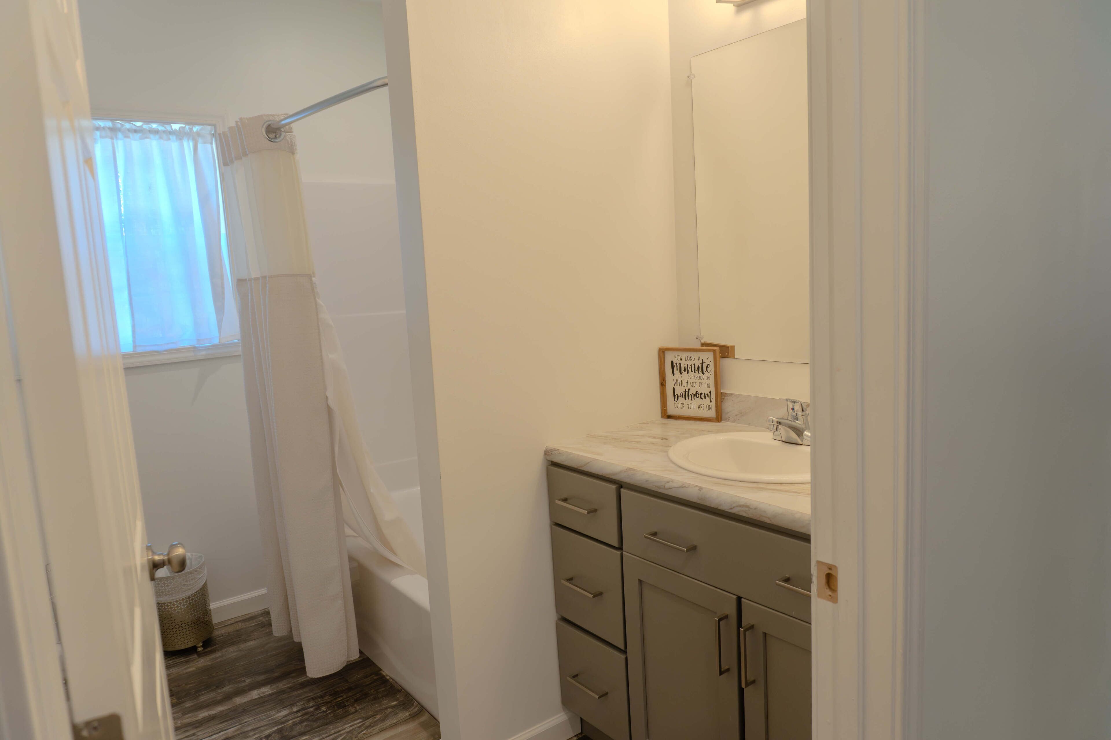 A bathroom with a shower, a sink, and a mirror.