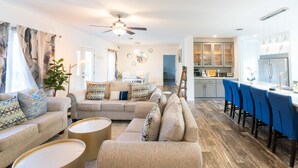A living room with a sofa, coffee table, and a dining area with chairs and a table. - Golden Lantern @ Acadia National Park, A/C, Spacious, Seafood (Tremont)