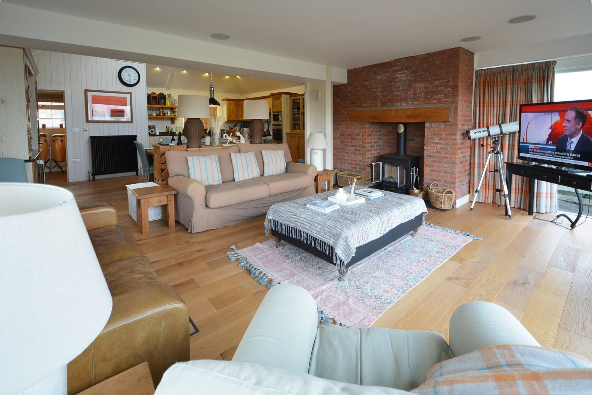 Ein gemütliches Wohnzimmer mit Sofa, Couchtisch, Kamin und Fernseher.