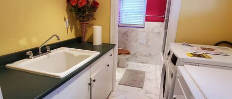 Cocina pequeña con lavabo, armarios y lavadora.