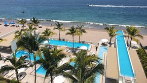 Ett semesterhotell med pool, strand och utsikt över havet.