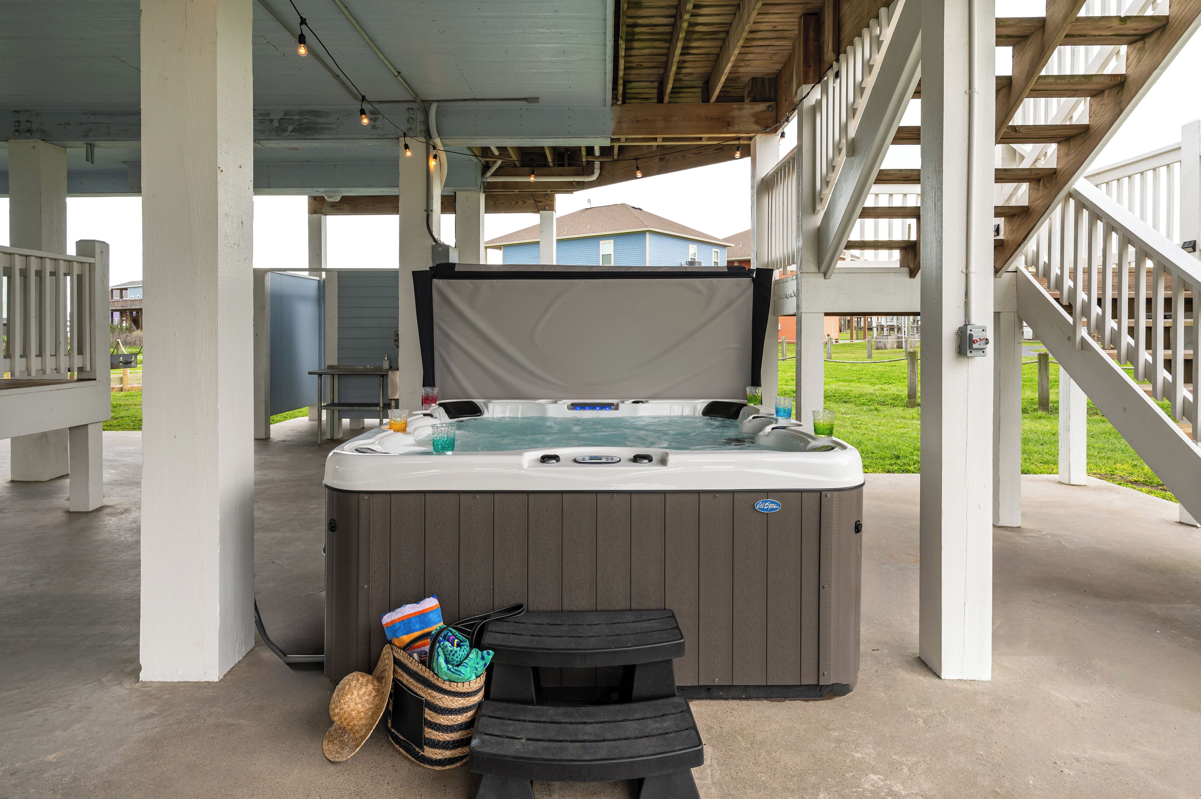 A hot tub with a cover, a small table, and a trash bin.