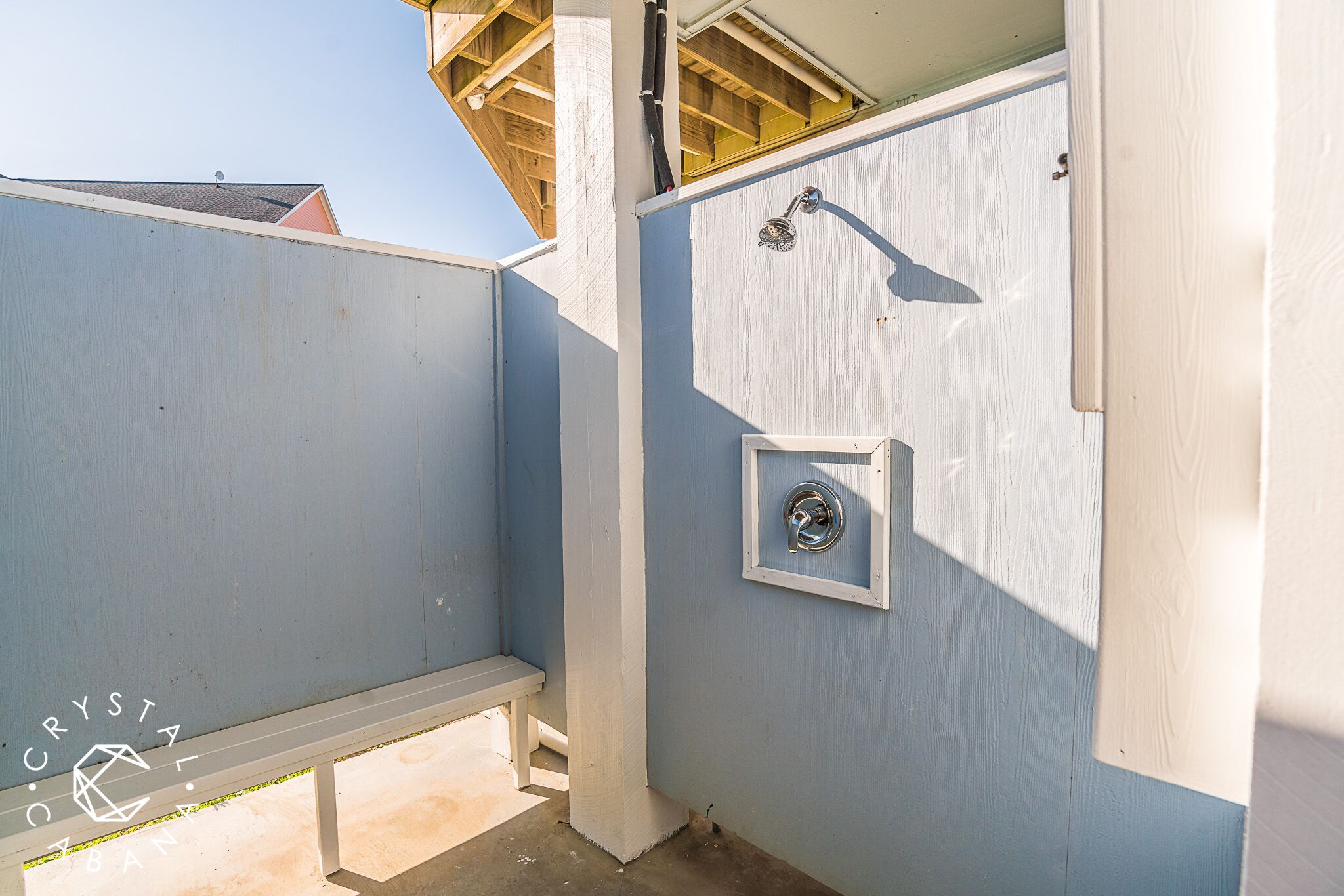 A bathroom with a shower, a toilet, and a bench.