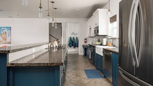 Una cocina moderna con encimeras de granito, electrodomésticos de acero inoxidable y armarios azules.