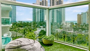 A balcony with a view of a cityscape, including tall buildings and palm trees. - OCEAN RESERVE LUXURIOUS CONDO 2MIN AWAY FROM BEACH (Sunny Isles Beach)