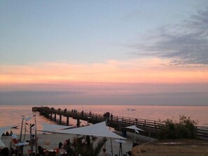Un molo si protende in acque calme al tramonto.