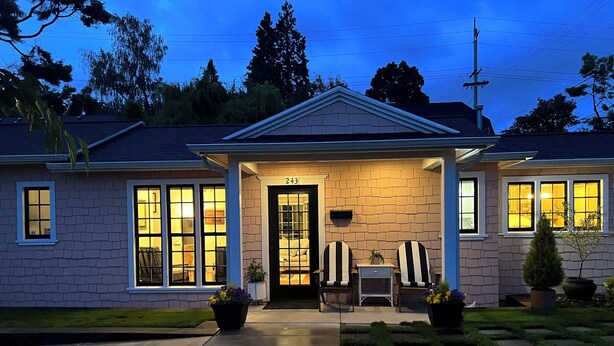 A two-story house with a front porch, a number '243' above the door, and a small table with chairs outside. - Fabulous Bungalow, 1 block from 5th Street Market (Eugene)