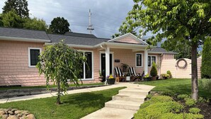 A residential house with a front porch, a small garden, and a pathway leading to the entrance. - Fabulous Bungalow, 1 block from 5th Street Market (Eugene)