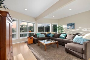 A living room with a brown sofa, a glass coffee table, and a wooden cabinet.