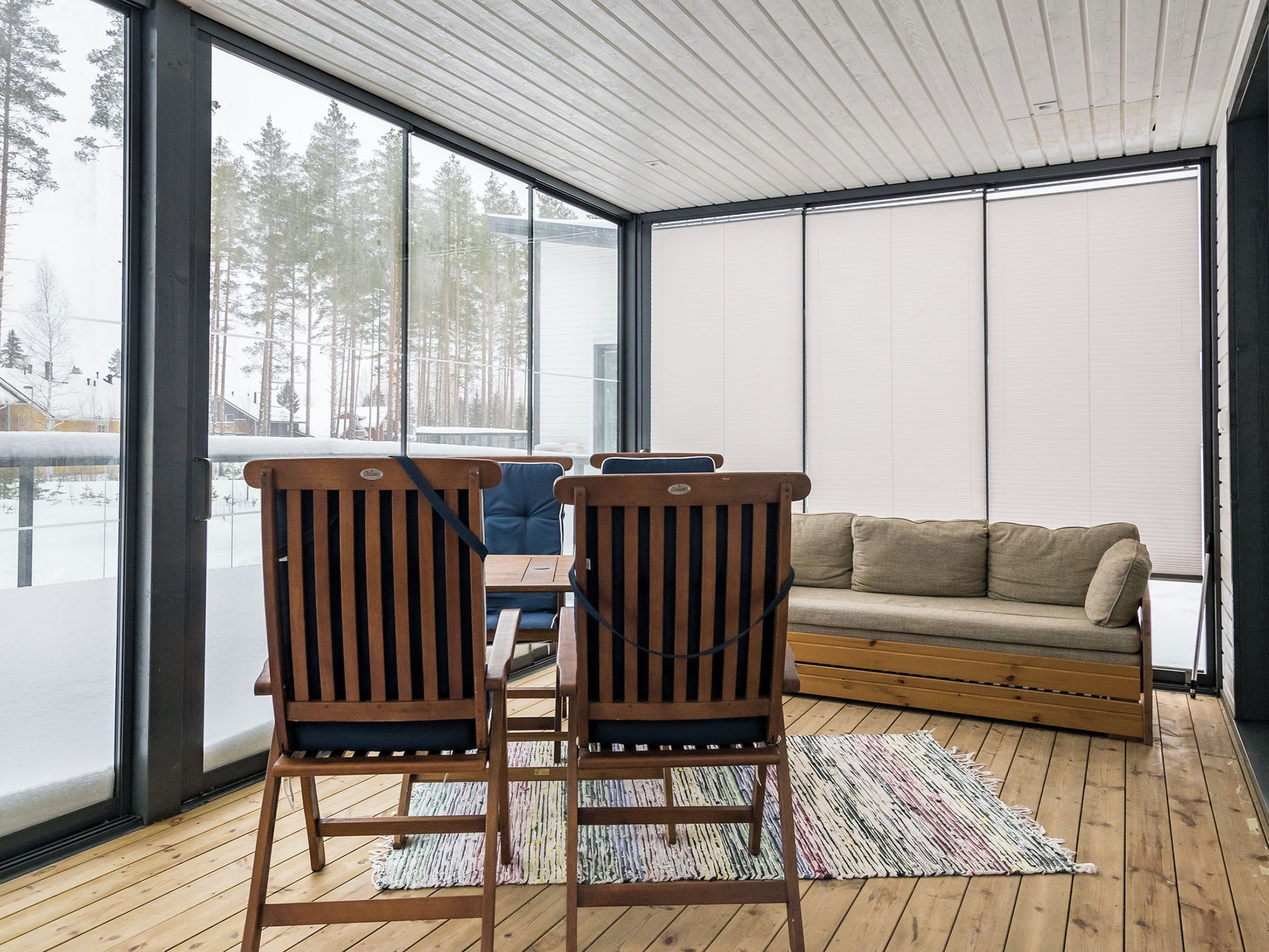Ein modernes Interieur mit einem Holzboden, einer Couch und zwei Sesseln.
