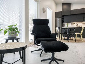 A modern living room with a black armchair, a small round table, and a potted plant. - Villa kuortane by Interhome (Kuortane)