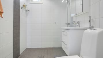 Moderni kylpyhuone, jossa on suihku, wc ja pesuallas.