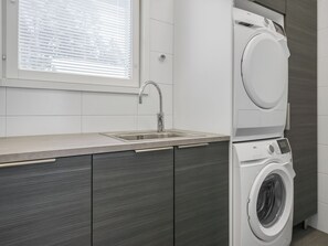 A modern laundry room with a built-in washing machine and a sink. - Villa kuortane by Interhome (Kuortane)