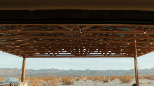 An outdoor patio with a wooden deck, a seating area with cushions, a grill, and a pool. - Private Luxury Glamping w/Celestial Views (Joshua Tree)