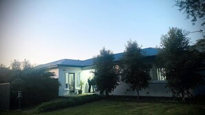 Una casa moderna con techo plano, porche delantero y césped cuidado.