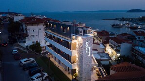 Un hotel de varios pisos con fachada de piedra y balcones con vistas a un puerto deportivo.