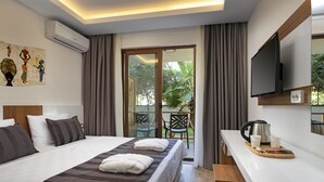 Quarto de hotel com cama, televisão, máquina de café e vista para o exterior.