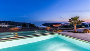 A swimming pool with a view of a coastal area at dusk. - 2 bedroom beautiful apartment in Banjole (Banjole)