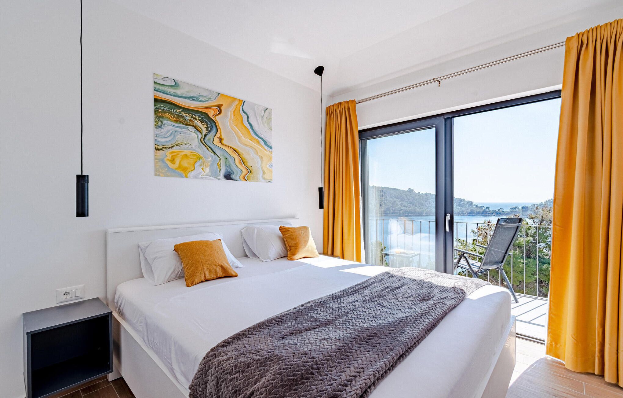 Una camera da letto moderna con un letto grande, vista sull'esterno e un quadro appeso al muro.