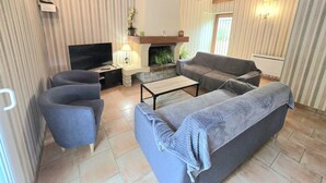 Ein Wohnzimmer mit Kamin, Fernseher und zwei Sofas.
