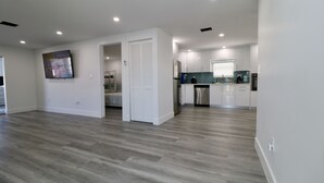 Una cocina moderna con armarios blancos, un refrigerador de acero inoxidable y un salpicadero de azulejos.