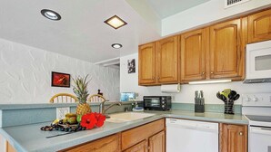 A kitchen with wooden cabinets, a microwave, a dishwasher, and a sink.