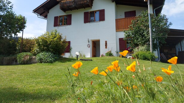 Ein zweistöckiges Haus mit Balkon, Tür und Fenster.