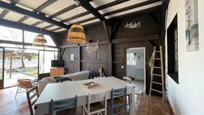 A rustic interior with a large dining table, wooden beams, and a hanging light fixture. - Charming gite for 10 people with heated pool and mini farm near the ocean (Azur)