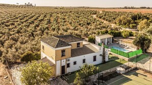 Un bâtiment à deux étages, doté d’un toit en tuiles, d’une piscine et d’un jardin.