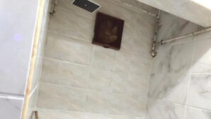 Een kleine badkamer met toilet, douche en wastafel.