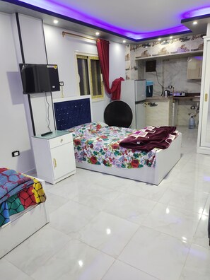 Ein Schlafzimmer mit Bett, Fernseher, Kleiderschrank und Bad.