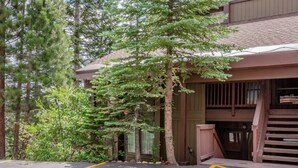 A building with a wooden exterior, a staircase, and a parking area with yellow lines. - Pet-Friendly, Updated Décor. Washer/Dryer, Balcony, Short Walk to The Village (Mammoth Lakes)