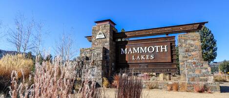 A sign for Mammoth Lakes with a stone and wood structure.