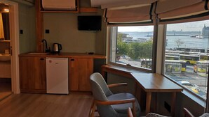 A compact kitchen with a refrigerator, a coffee maker, and a television on the wall. - Panorama Suite (Istanbul)