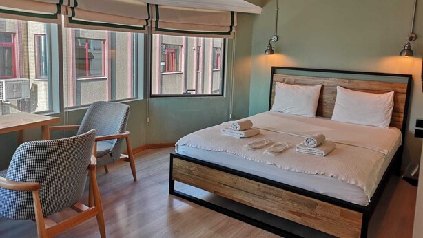 A bedroom with a bed, a chair, and a desk. - Panorama Suite (Istanbul)
